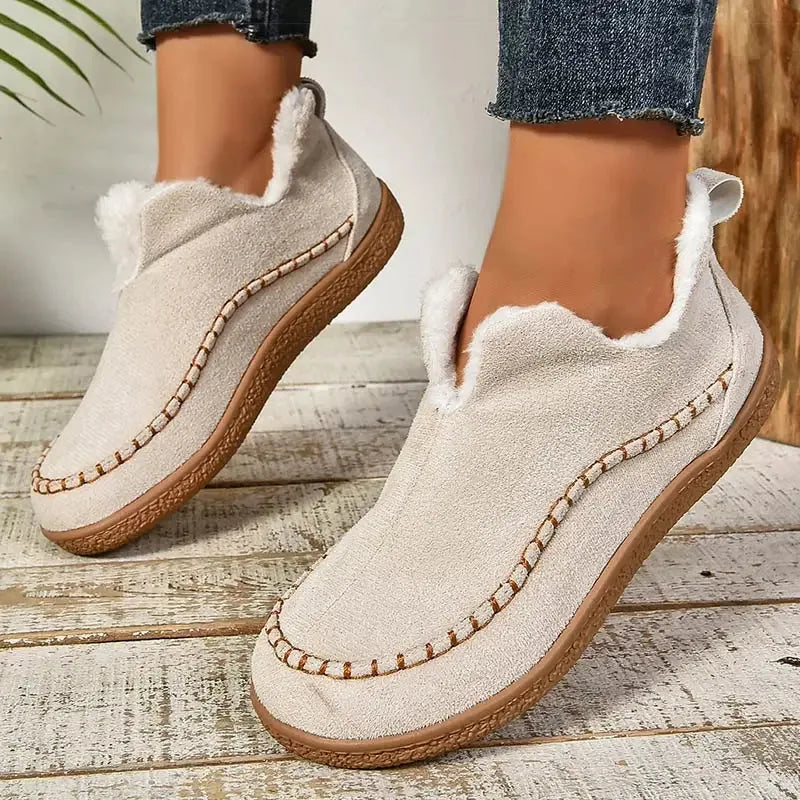 Pair of beige suede ankle boots viewed from above showing the fur-lined opening and stitched vamp