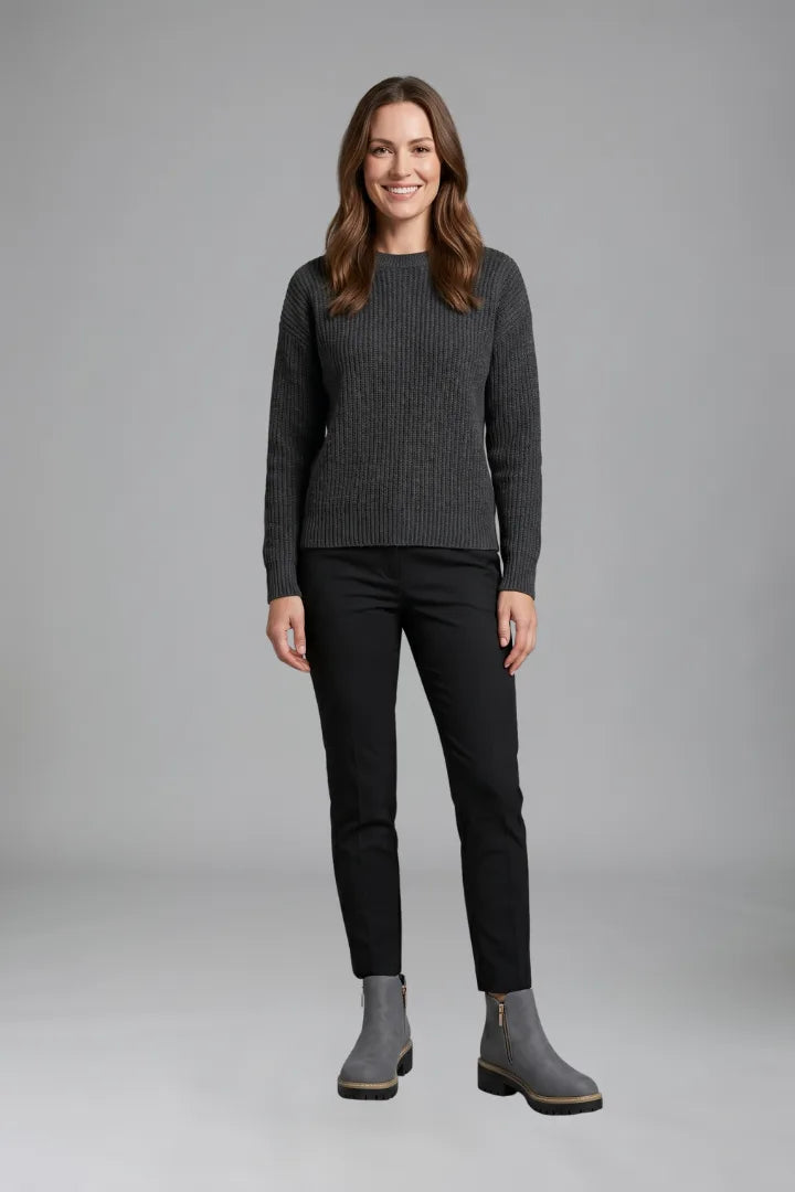 Woman wearing a grey ribbed jumper and black trousers styled with grey ankle boots and gold zip detail