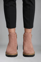 Close-up back view of pink suede-effect ankle boots showing the gold side zip and ridged black sole