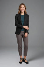 Woman in grey trousers and black blazer wearing black crisscross-strap ballet flats