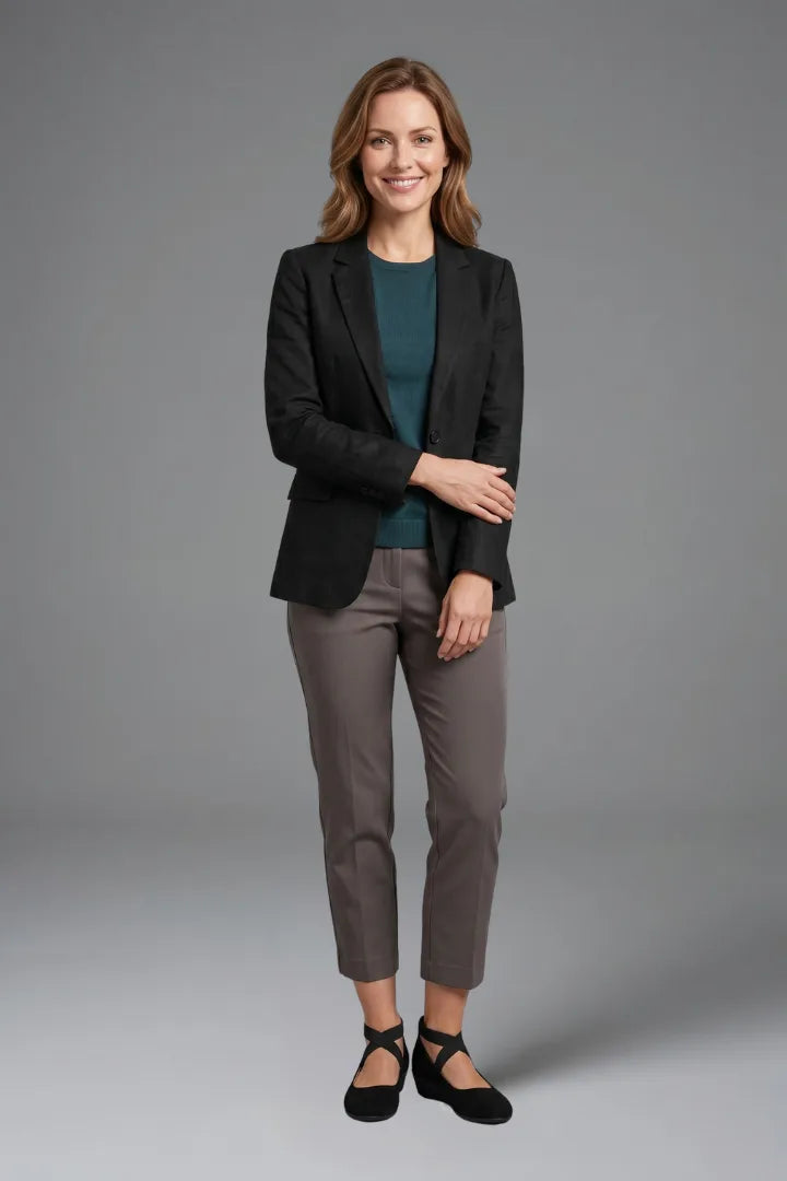 Woman in grey trousers and black blazer wearing black crisscross-strap ballet flats
