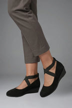 Close-up side profile of black ballet flat showing rounded toe and elastic instep strap