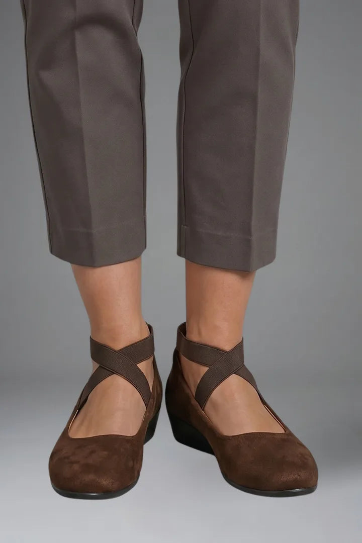 Front view of feet wearing brown suede ballet flats with crisscross elastic straps