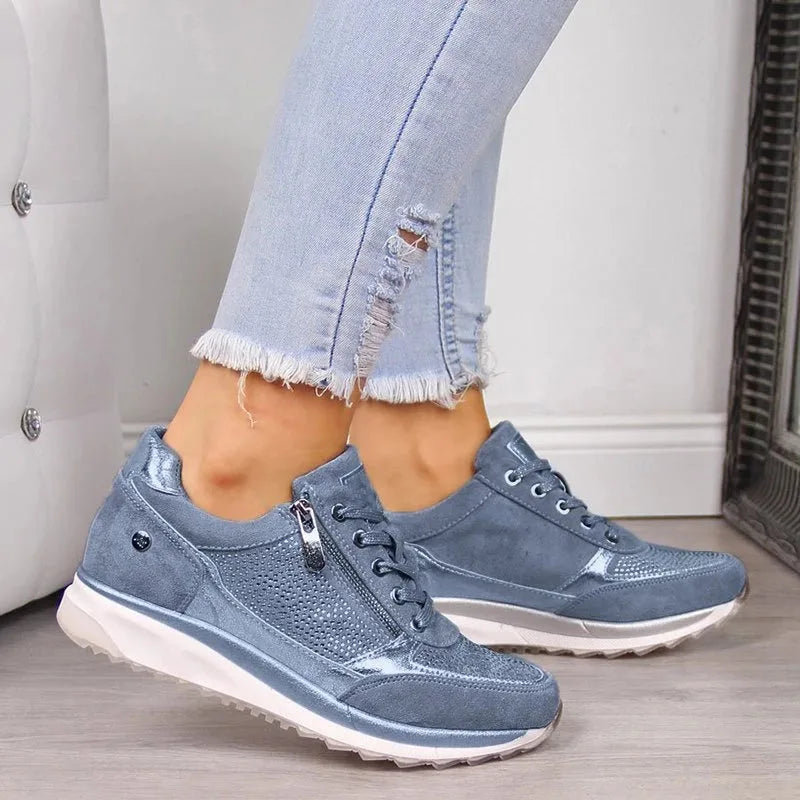 Grey suede trainer with silver zip pull and studded button detail on the side panel