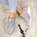 Beige and bronze trainers with sparkly gold laces displayed together on a flat surface