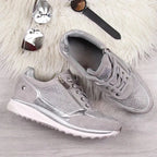 Close-up front view of grey trainers with crystal toe panel worn with distressed jeans