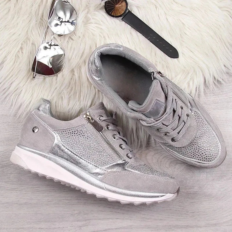 Close-up front view of grey trainers with crystal toe panel worn with distressed jeans