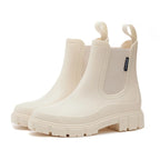White rubber Chelsea rain boots with elastic side panel, chunky treaded sole and rear pull loops.