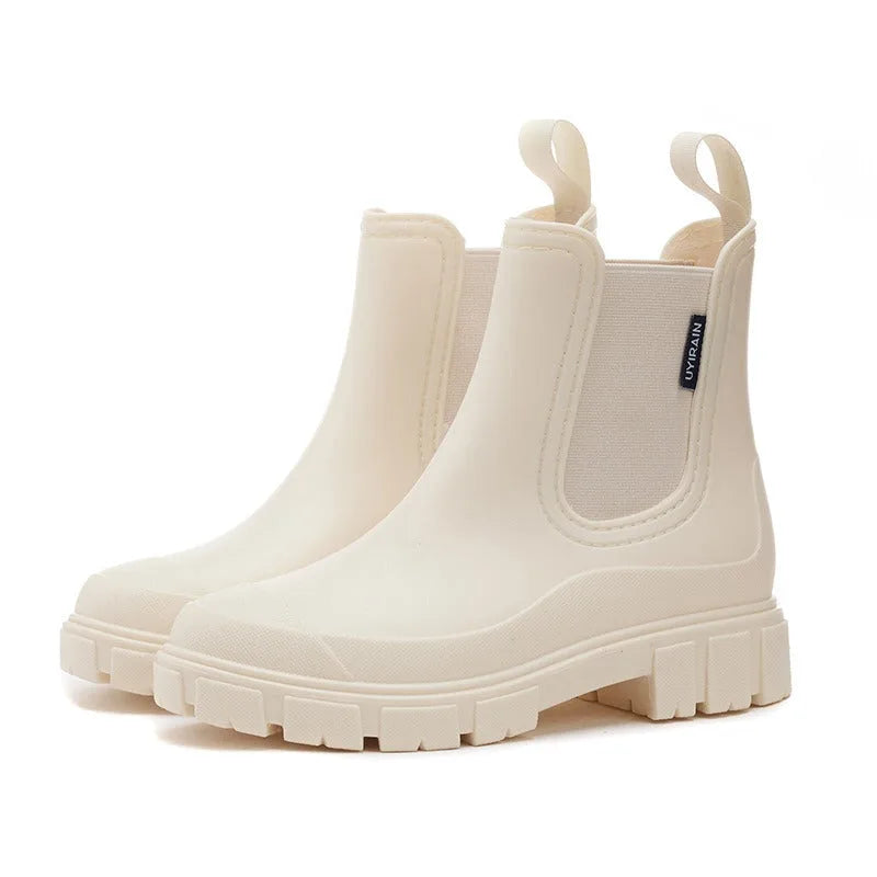 White rubber Chelsea rain boots with elastic side panel, chunky treaded sole and rear pull loops.