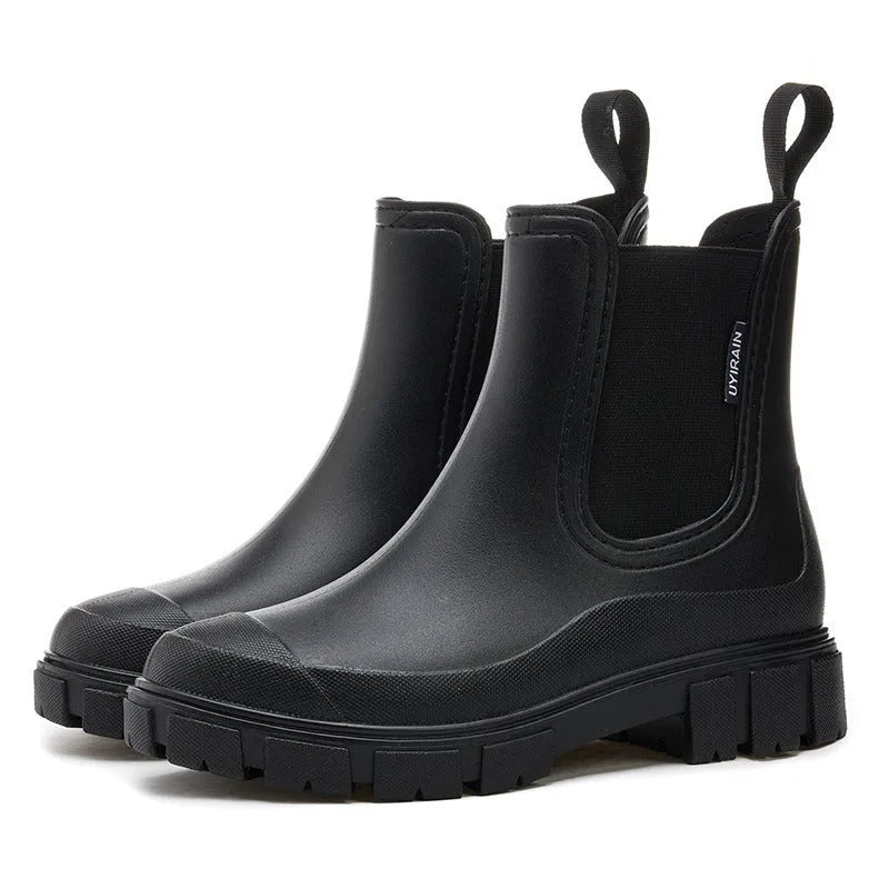 Black Chelsea rain boots in matte rubber, front view showing rounded toe and platform tread sole.