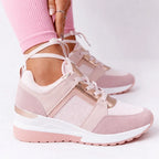 Pink and rose gold mesh wedge trainers with lace-up tie detail, worn with pink leggings