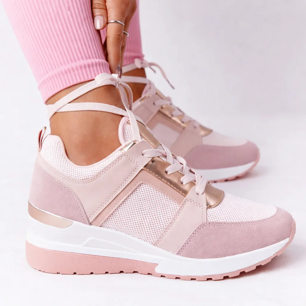 Pink and rose gold mesh wedge trainers with lace-up tie detail, worn with pink leggings