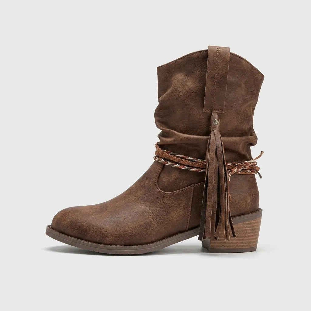 Studio side profile of a single brown slouch boot showing pull tab, tassel and block heel construction