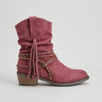 Studio side profile of a dusty pink suede-look slouch boot with braided ankle wrap and knotted tassel