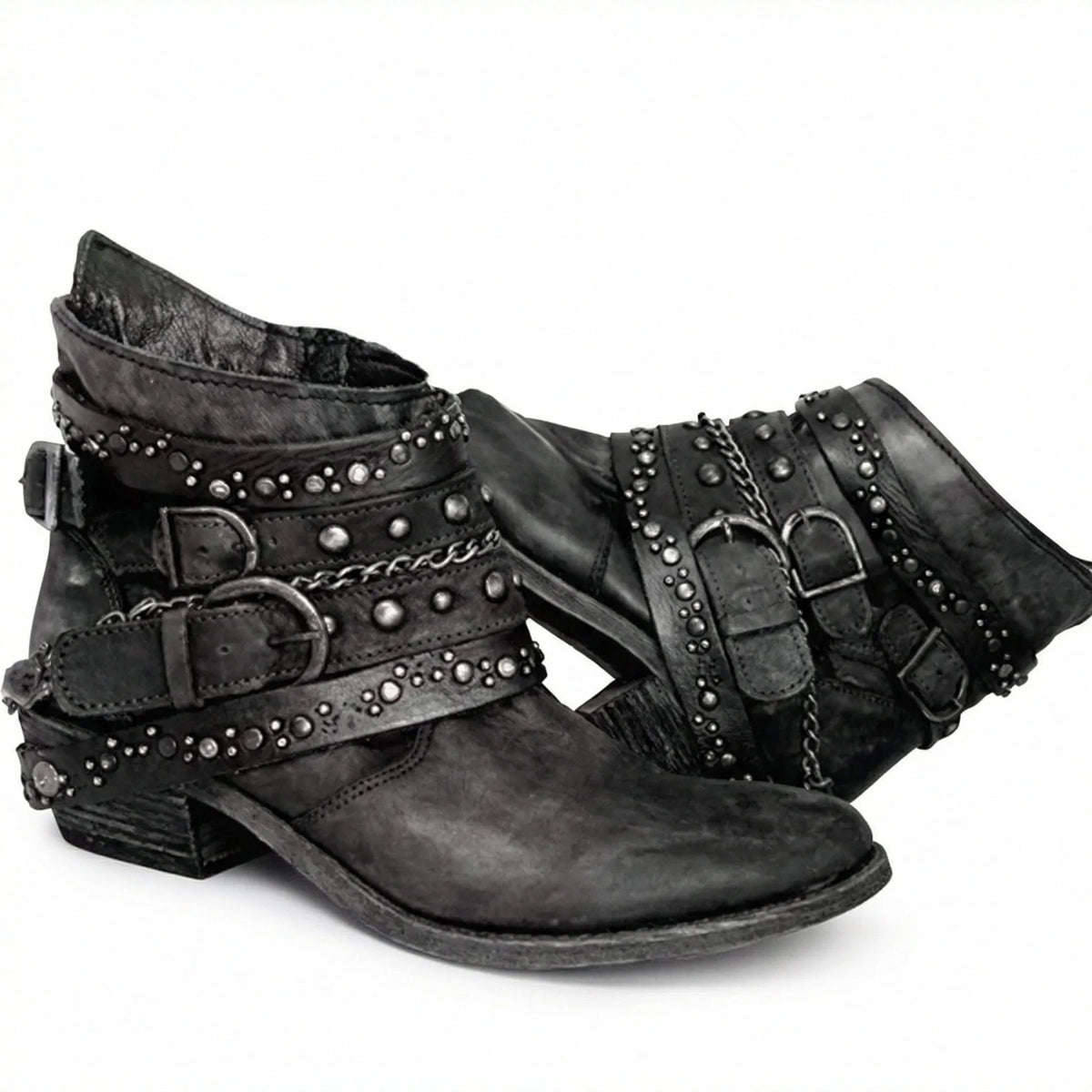 Pair of black distressed leather ankle boots with studded straps and chain accents, side by side
