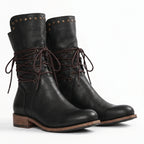 Pair of black leather lace-up mid-calf boots standing together against a plain white background