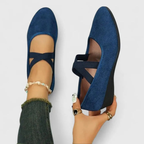 Overhead and side view of navy blue suede ballet flats with elastic crossover straps and low wedge heel