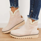 Side view of blush pink suede ankle boot with cream faux fur trim, whipstitch detail and tan heel patch, worn with jeans
