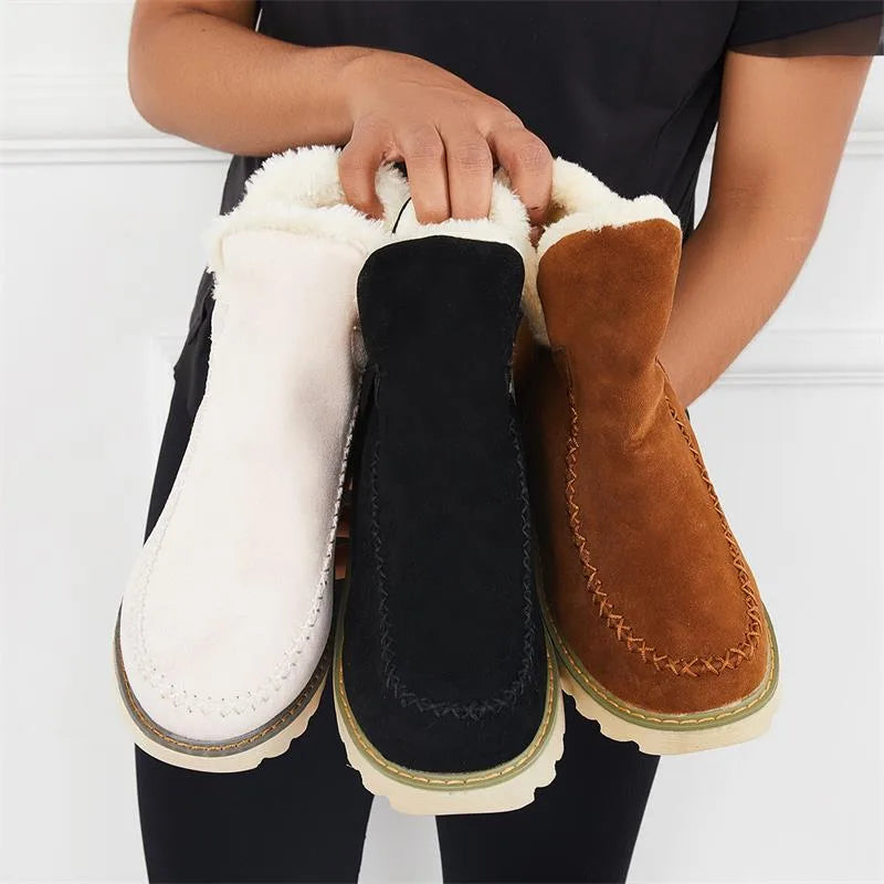 Three ankle boots lined up in blush pink, black and tan brown, all with matching faux fur trim and soles