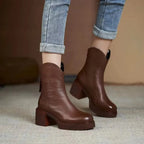 Front angle of brown leather Chelsea boots worn with cuffed denim, highlighting stitched seam and platform sole