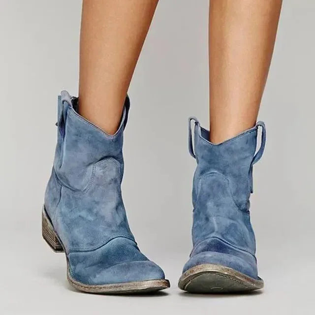 Blue suede cowboy ankle boots showing distressed finish, curved heel and seam detailing at the front.
