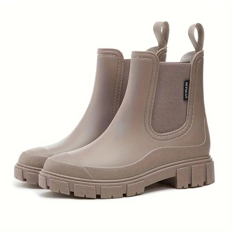 Side angle of taupe waterproof Chelsea boot showing lug sole, elastic gusset panel and pull-tab heel loop