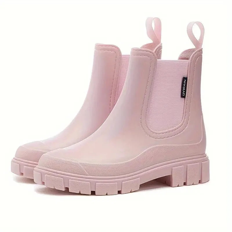 Pale pink slip-on ankle boots with elastic side panel and rubber pull tabs, shown from a three-quarter angle