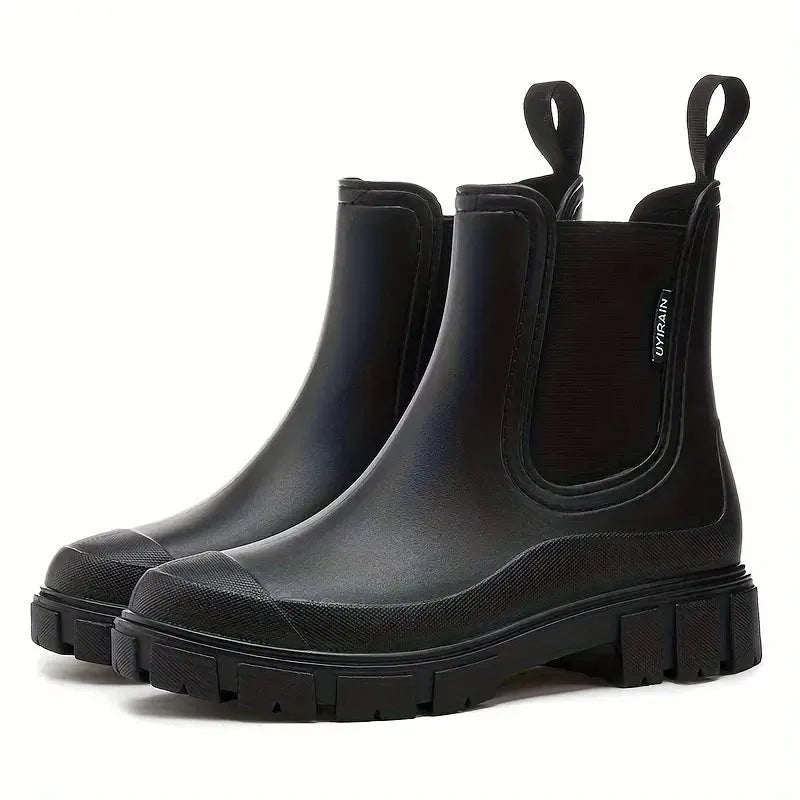 Matte black waterproof ankle boots shown side-on, showcasing the pull-loop heel tabs and chunky tread