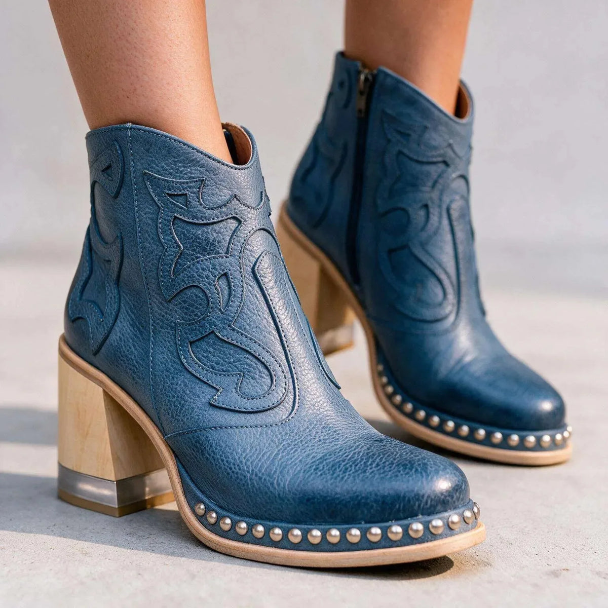 Blue leather ankle boots pictured from the side, showing the side zip fastening and stacked wood heel