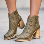 Olive green leather ankle boots showing weathered tonal finish and side zip closure on the ankle