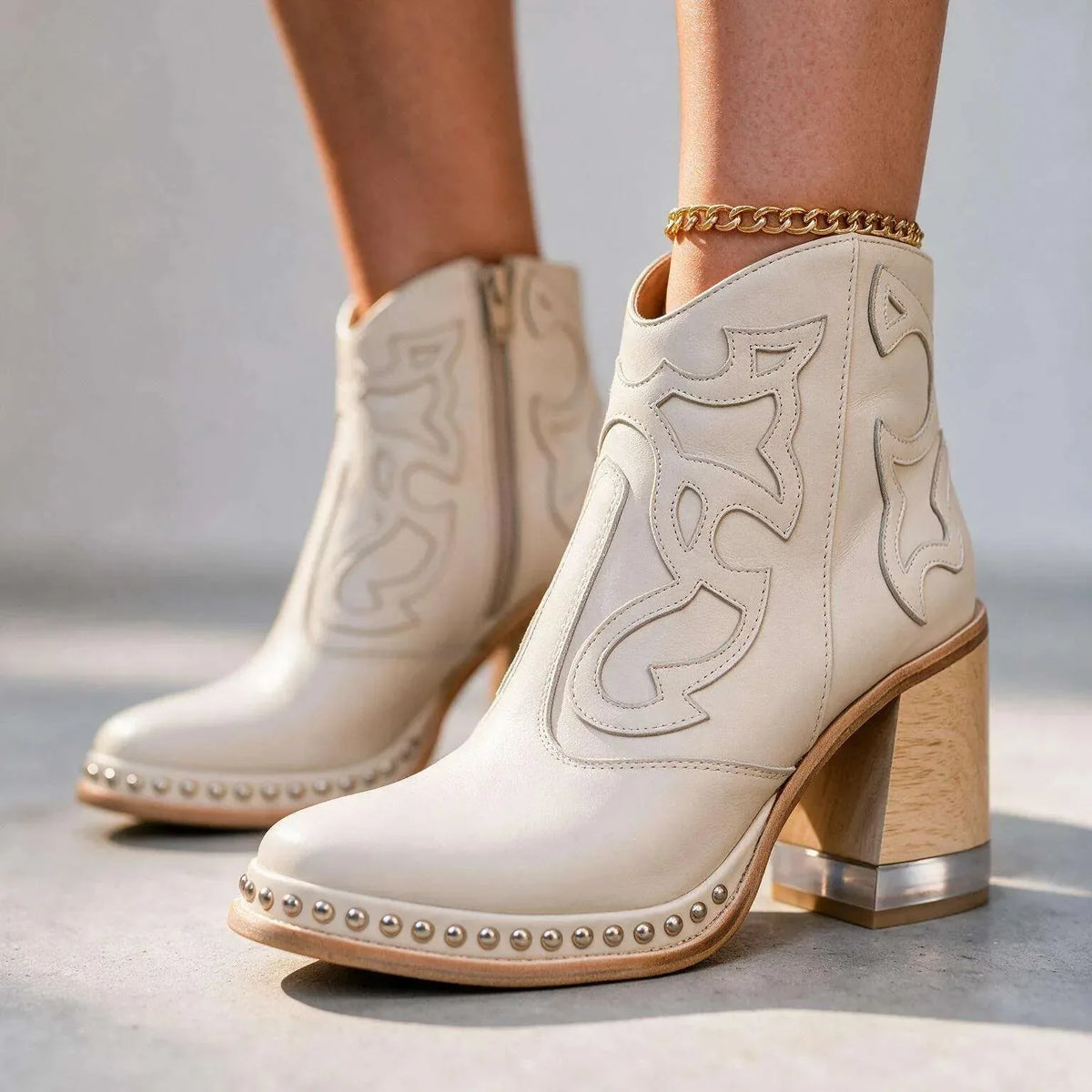Off-white leather ankle boots with cream stitched panels, studded platform and gold anklet accessory