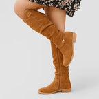 Tan suede knee-high slouch boot with visible side zip and button ankle strap detail