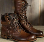 Dark brown leather combat boots with fold-over cuff and tan leather trim detail