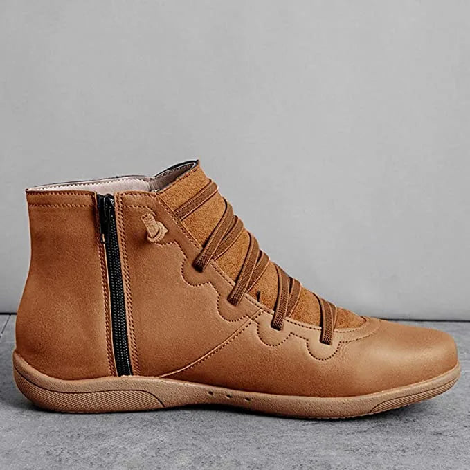 Single tan brown leather ankle boot shown from the side, highlighting the zip and scalloped panel
