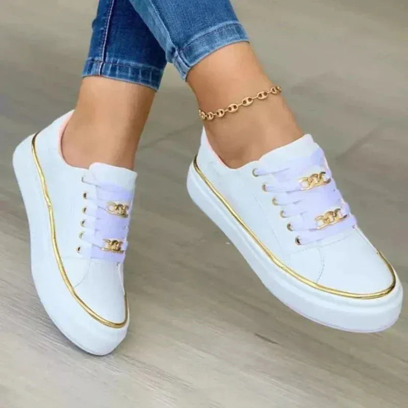 White lace-up trainers with lilac laces, gold chain trim and gold piping along the platform sole