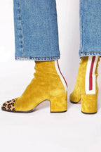 Detail shot of the block heel and sole on a suede ankle boot, showing the stacked heel construction
