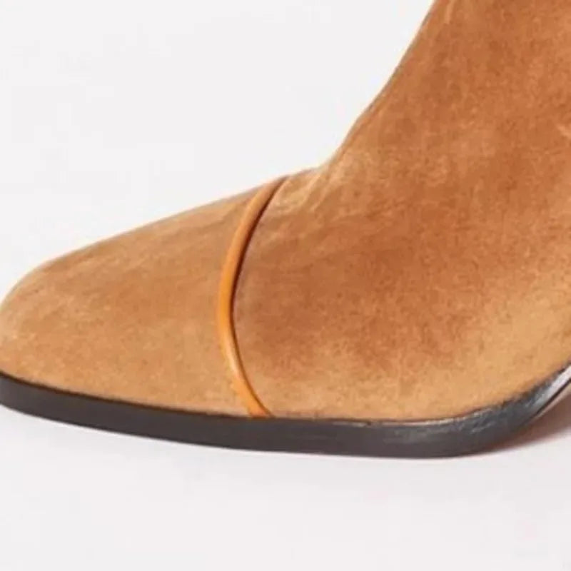 Close-up of tan suede toe cap showing a thin leather trim detail along the seam