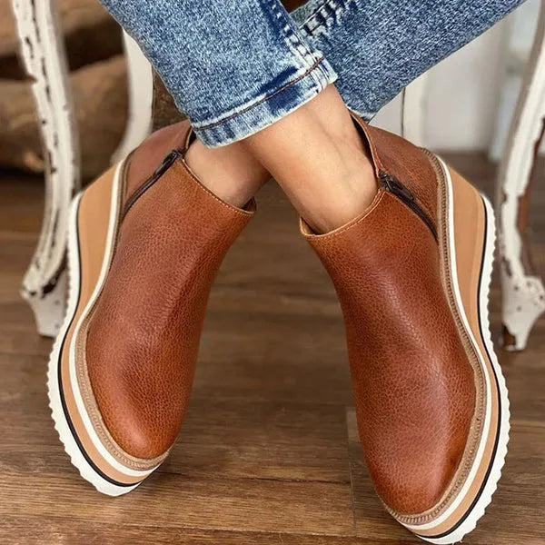 Rear view of brown leather wedge boots showing heel shape and stacked platform construction
